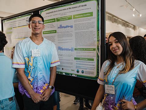 Proud students posing in front of their data display.